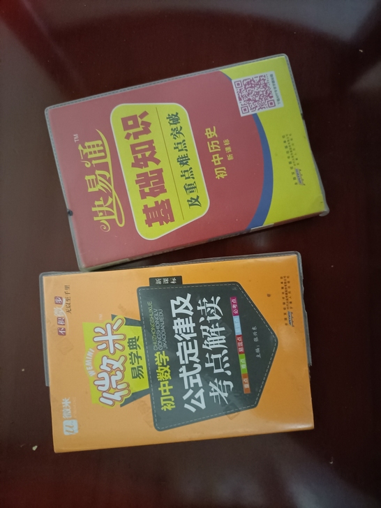出两本小书,初中的,一个历史一个数学,橙色...