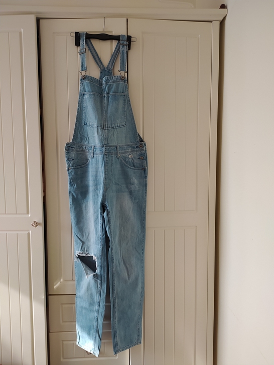 浅蓝HM背带牛仔破洞裤。