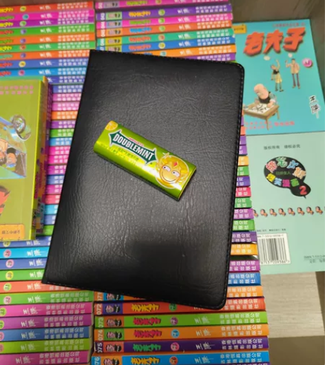 放在100册老夫子上的笔记本和薄荷糖空盒 ...